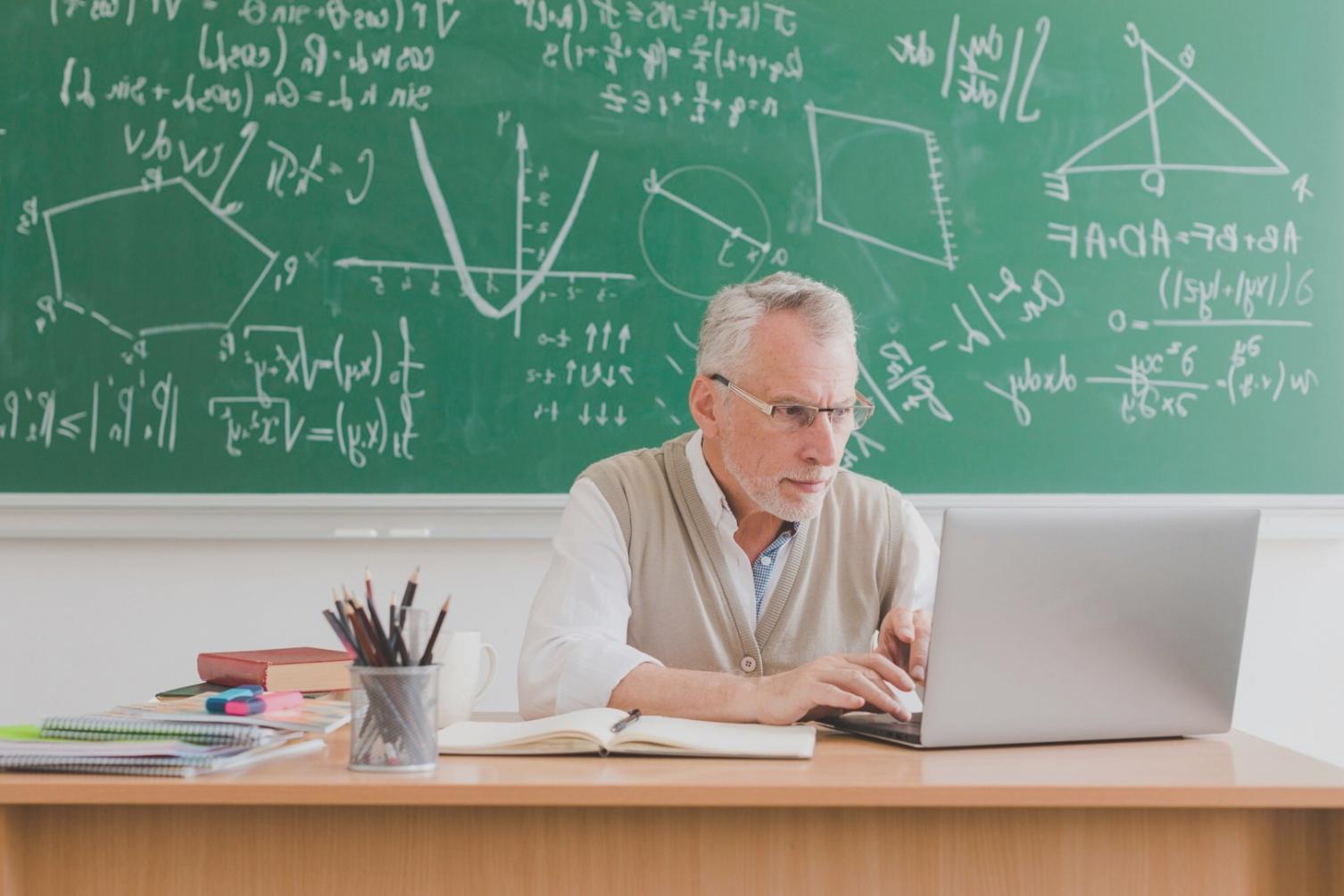 Teilnehmer bei einer interaktiven Finanzanalyse-Session mit Laptops und Präsentationsbildschirmen